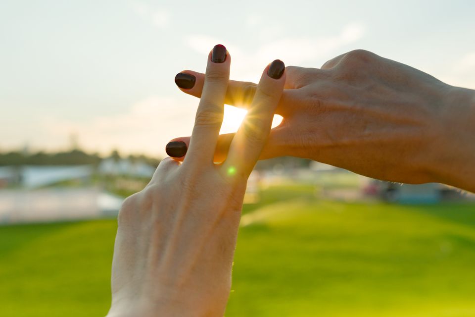To hænder former et hashtag i en solnedgang