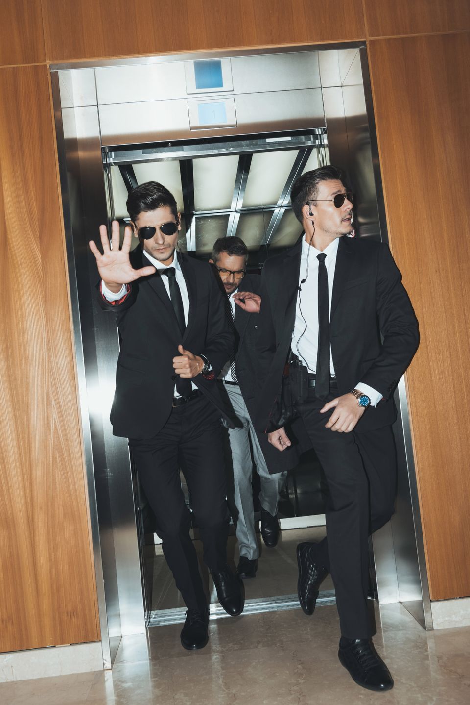 Bodyguards eskorterer mand ud af elevator